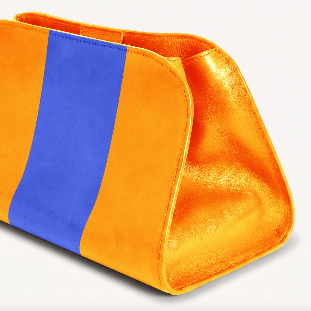 A close-up of a structured cosmetic pouch or clutch in bright yellow with a bold vertical blue stripe on the front, shown on a clean white background.
