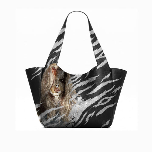 A black tote bag with a white zebra-stripe pattern and a printed portrait of a woman with long light brown hair on the front, shown against a plain white background.