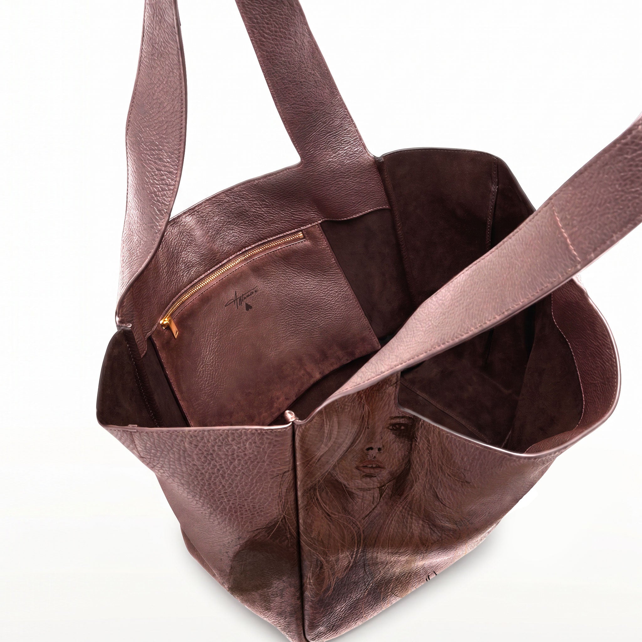 A dark brown leather tote bag with a printed portrait of a woman on the front panel, shown open against a plain white background.
