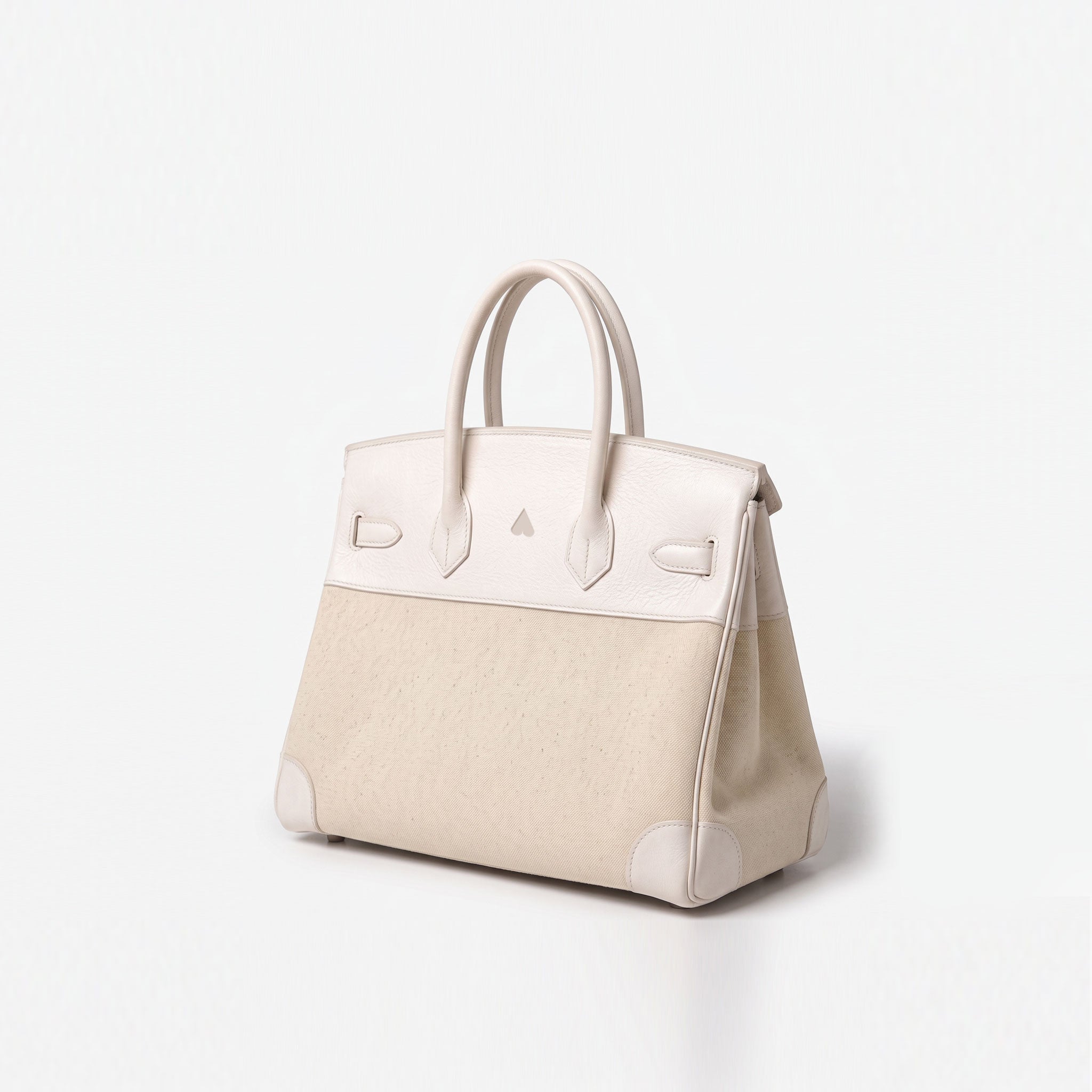 A structured handbag in light cream and off-white leather, featuring a textured front panel, smooth leather top flap, dual top handles, and protective corner bumpers, photographed on a seamless white background.