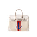 A structured cream-colored leather handbag with silver hardware, featuring a vertical red and white stripe design on the front with a blue anchor motif in the center.
