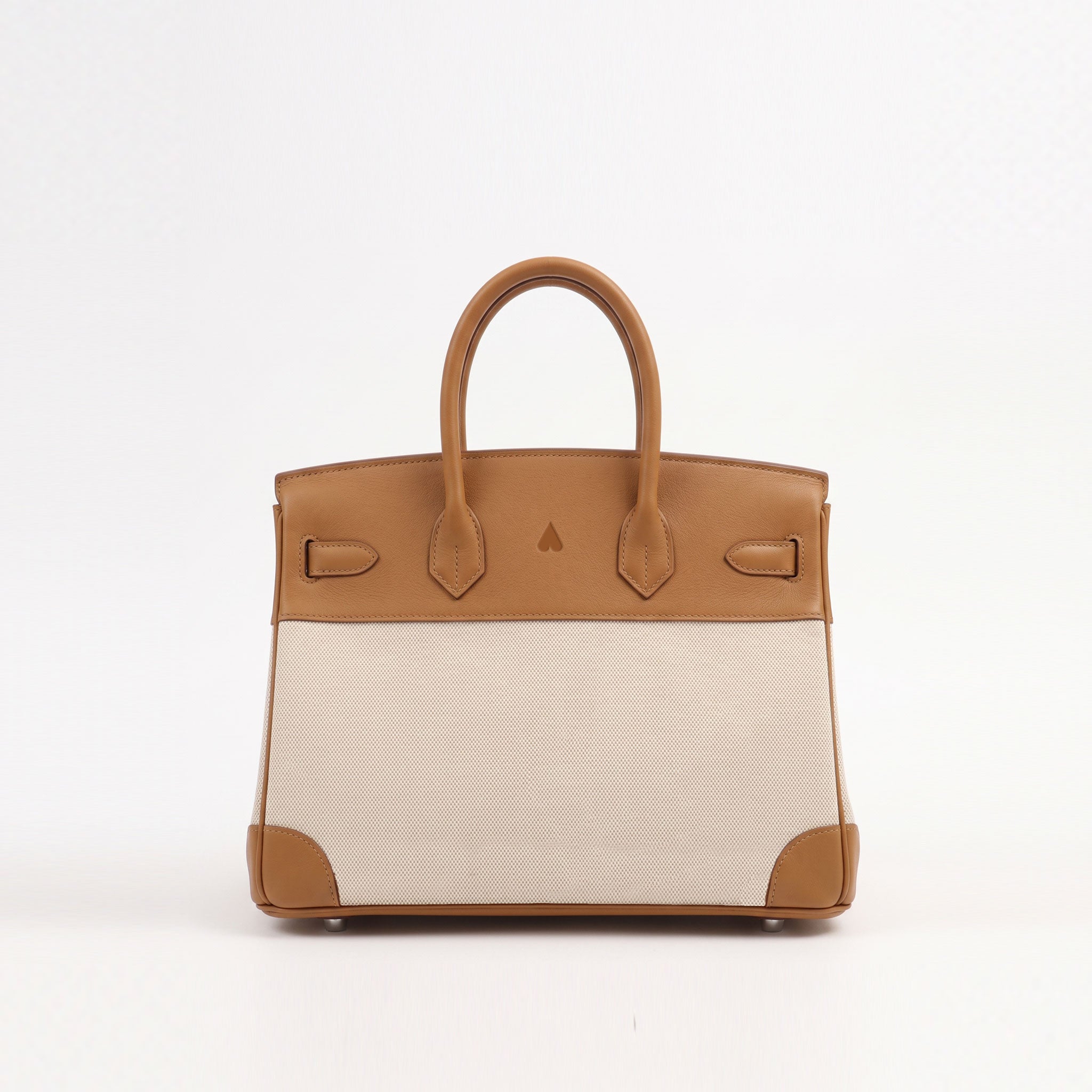 A structured leather handbag with a tan top panel and handles, a light beige woven body, and tan corner protectors, photographed against a plain white background.