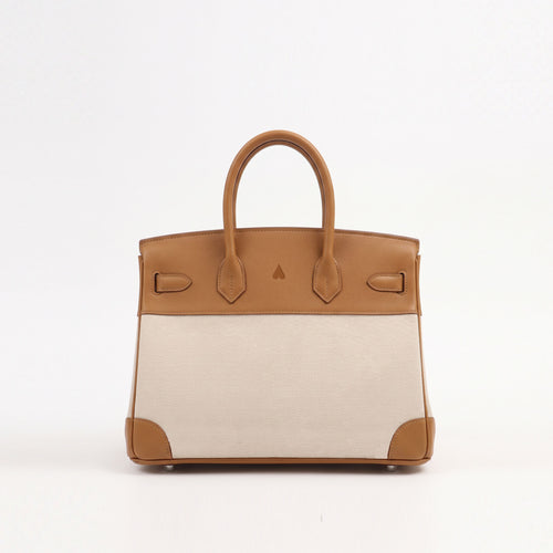 A structured leather handbag with a tan top panel and handles, a light beige woven body, and tan corner protectors, photographed against a plain white background.