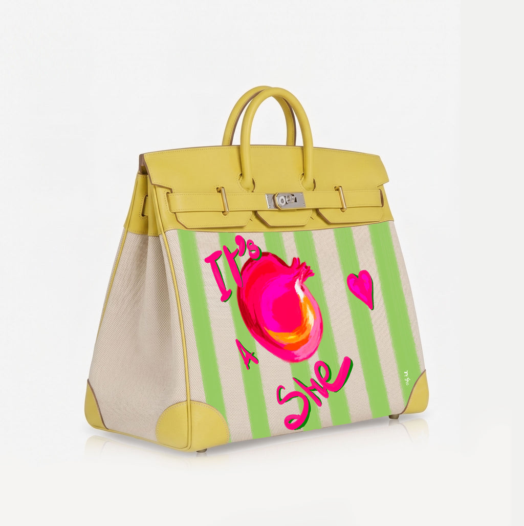 A structured leather handbag with a yellow top handle and trim, cream leather side panels, and a light green and cream striped front panel featuring a bright pink anatomical heart graphic and the text 'This is She' in pink script.