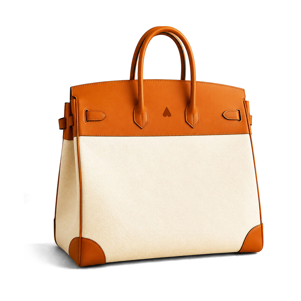 A structured leather handbag with a two-tone color-blocked design, featuring a warm tan leather top panel, handles, and corner protectors, paired with a cream-colored canvas body.