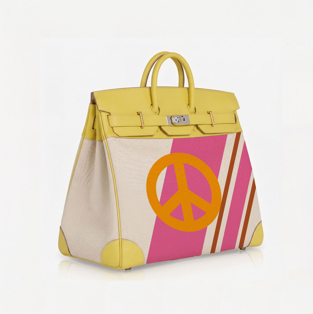 A structured leather handbag with yellow leather trim and handles, featuring a cream and pink striped body with a large orange peace sign graphic on the front.