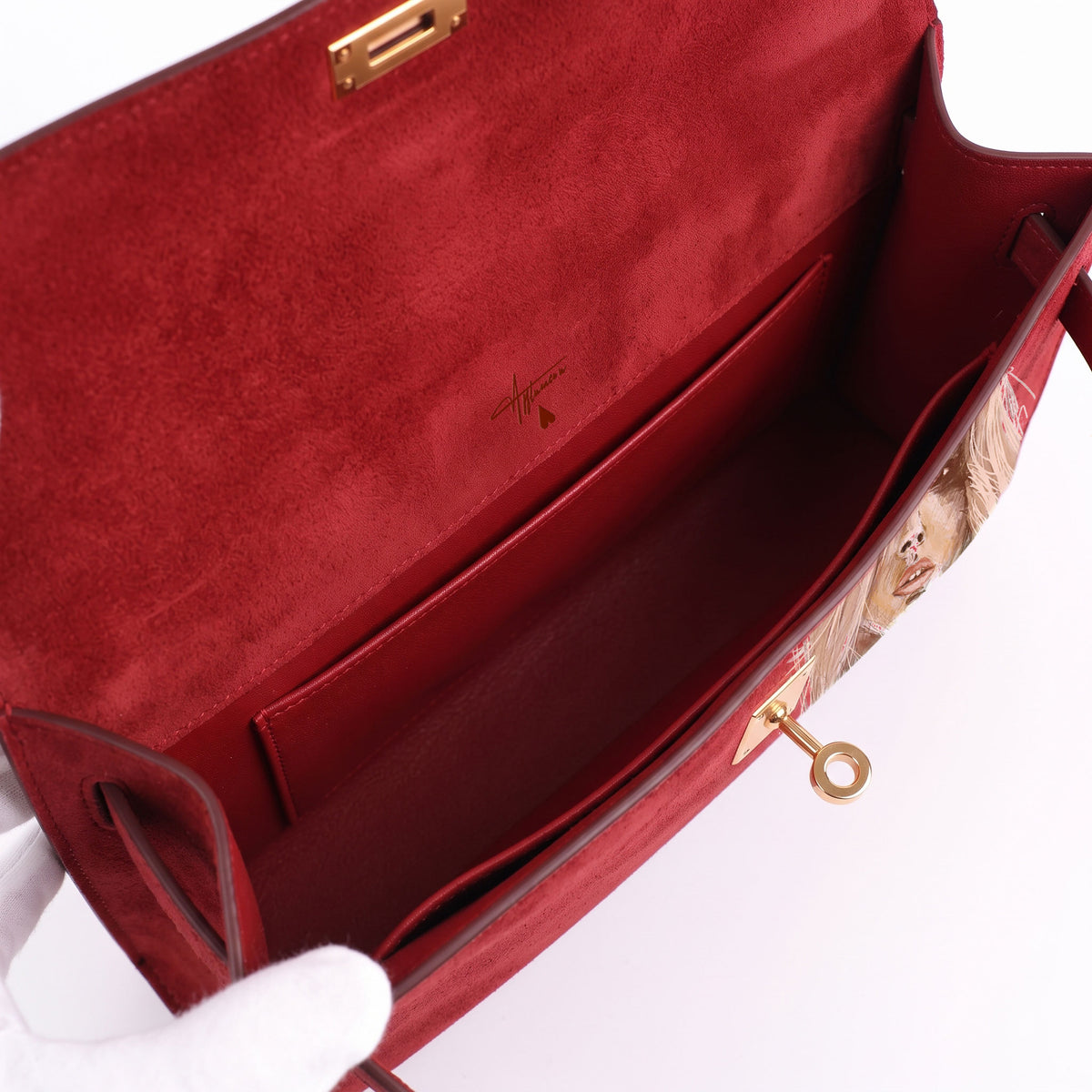 Crafted from luxurious red calfskin suede, the Kali Long clutch pochette combines a soft, velvety texture. Designed with a refined top handle, slim closure straps, and polished gold-tone twist-lock hardware, with front gorgeous art print, interior is red suede with inside pocket
