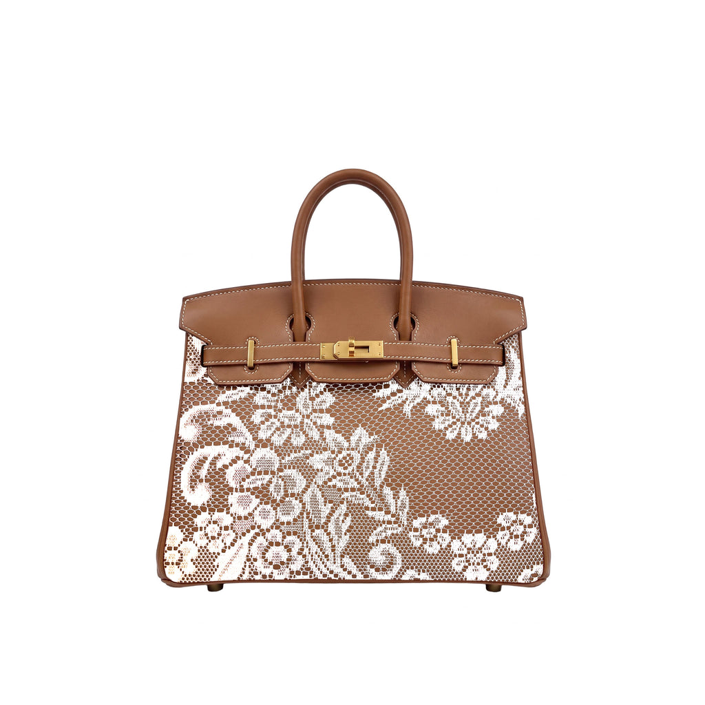 A structured brown leather handbag with a white floral lace overlay on the front, featuring gold-tone hardware and dual top handles, shown against a plain white background.