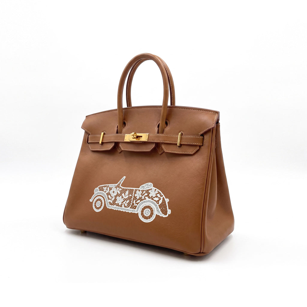 A brown leather handbag with gold-tone hardware and a white embroidered convertible car design on the front, photographed on a clean white background.