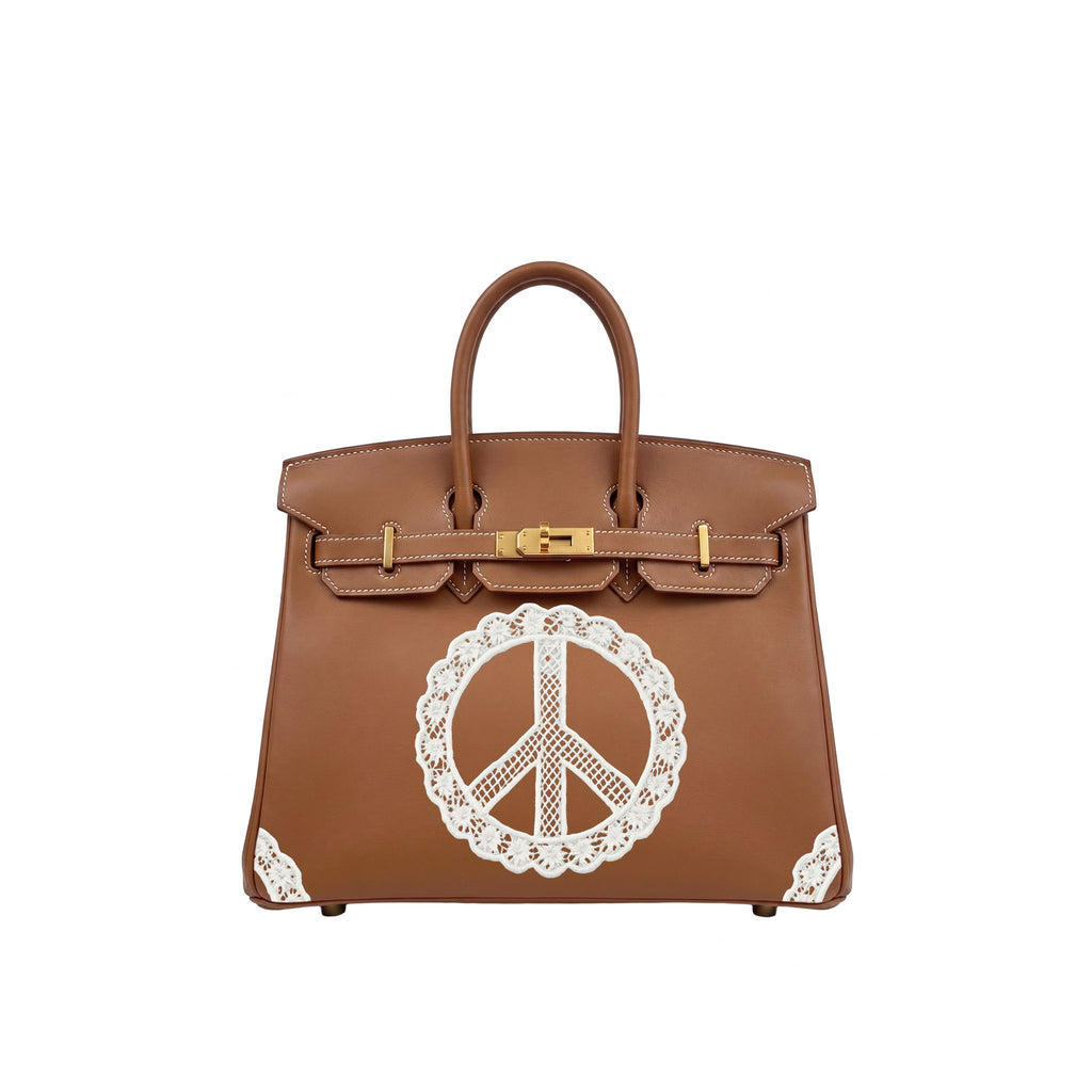 A brown leather handbag with gold-tone hardware and a large white lace peace sign applique on the front, shown against a plain white background.