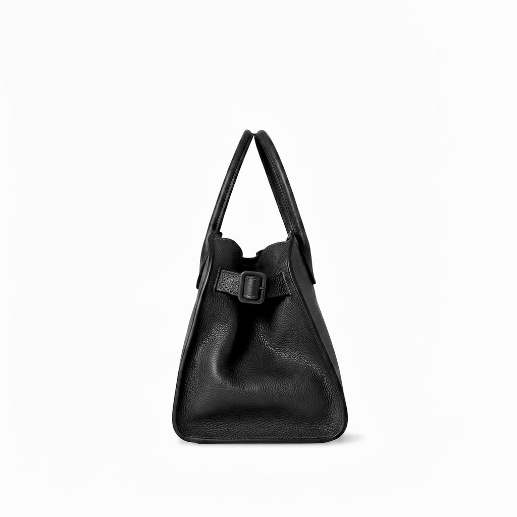 A black full grain leather handbag with dual top handles and a front strap detail with a buckle, shown against a plain white background.