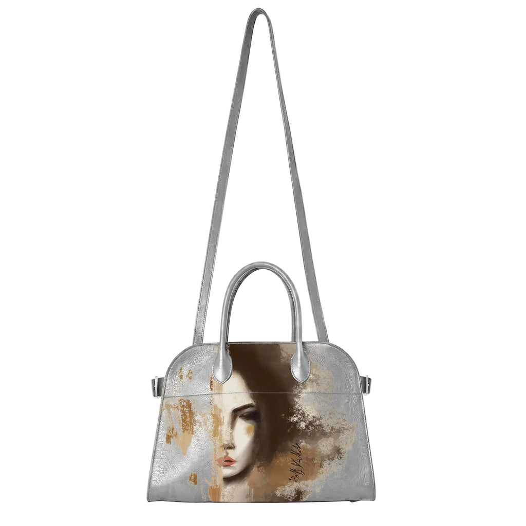 A structured silver handbag with a long shoulder strap and top handles, featuring a printed portrait of a woman on the front with a distressed, textured finish in brown, beige, and black tones.