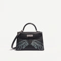 A black leather top-handle handbag with silver hardware and a shoulder strap, featuring two large Silver horse head illustrations on the lower front, photographed against a plain white background.