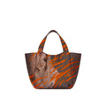 Eve Orange Zebra Handbag is crafted from supple deerskin leather with a naturally grainy finish and distinguished by a gorgeous artistic front print