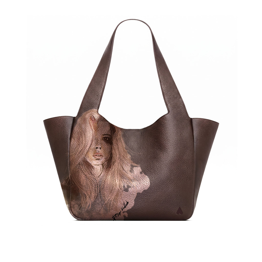 A dark brown full grained leather tote bag featuring a large, detailed portrait illustration of a woman with long light brown hair on the front panel, set against a plain white background.