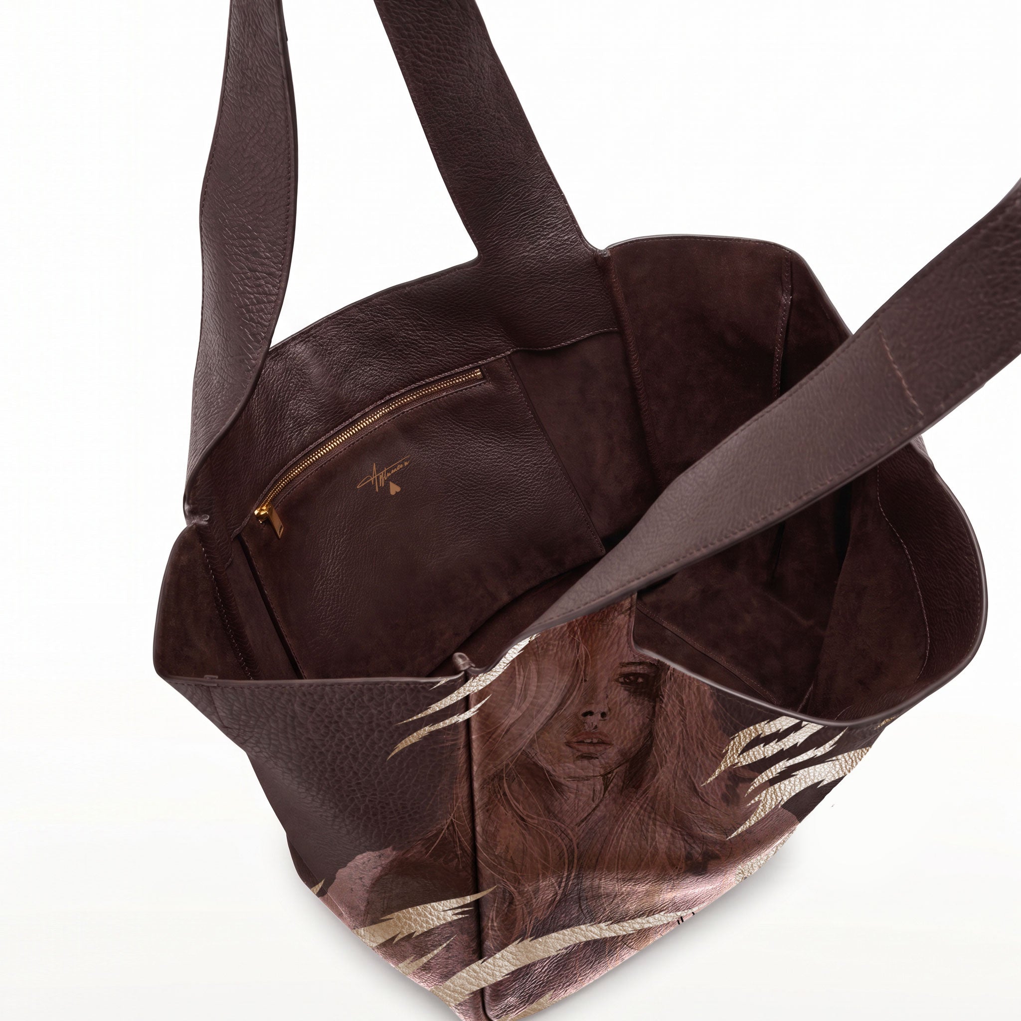 A dark brown leather tote bag with a printed illustration of a woman with long hair on the lower front panel, shown open against a white background.
