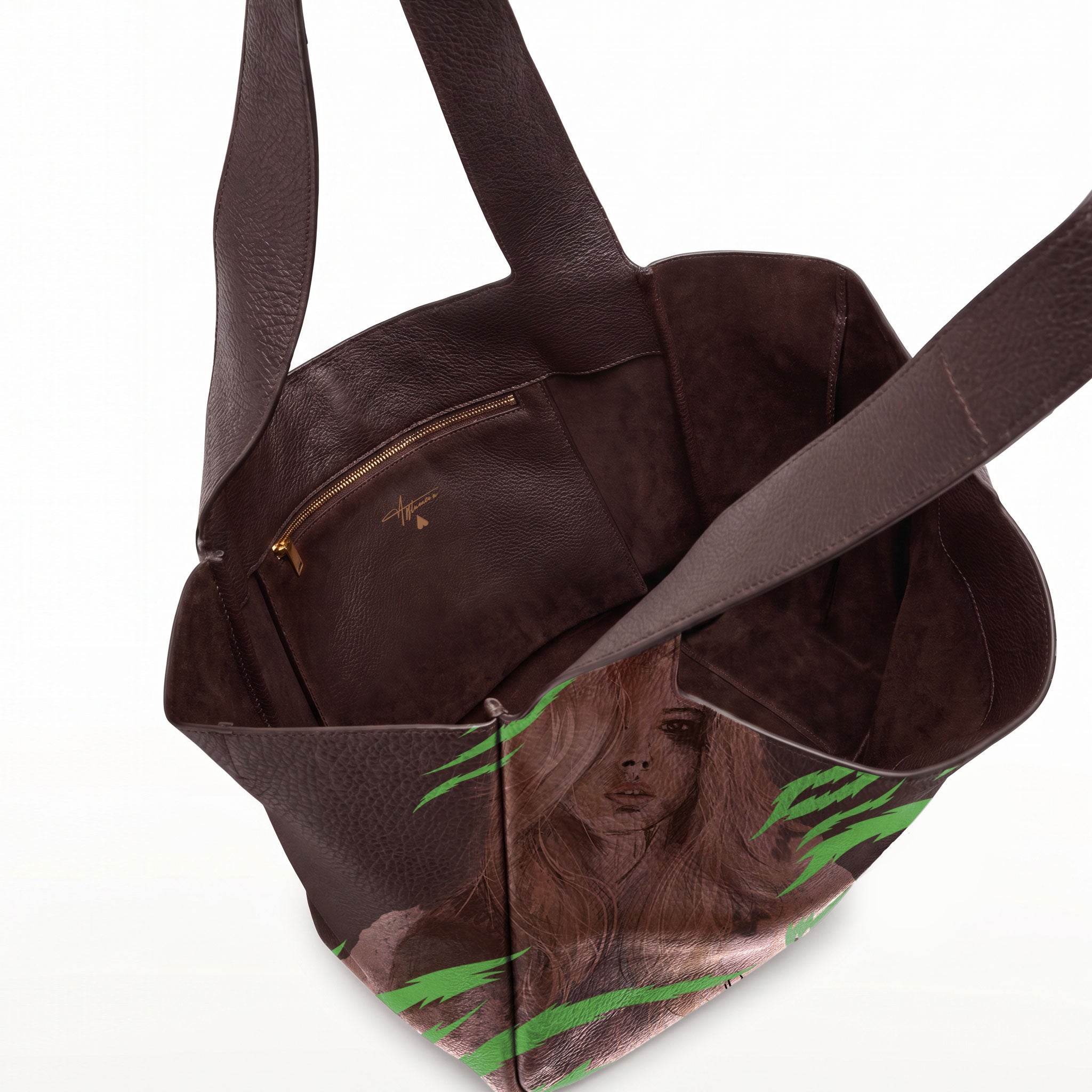 A dark brown leather tote bag with a printed illustration of a woman with long brown hair and green tiger print on the lower front panel, shown open against a white background.