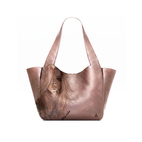 A bronze leather tote bag with a printed portrait of a woman on the front panel, shown open against a plain white background.