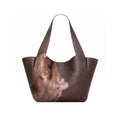 A dark brown leather tote bag with a printed portrait of a woman on the lower front panel and a zippered pocket inside, shown on a white background.