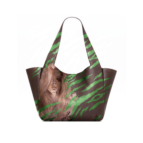 A dark brown leather tote bag with a printed illustration of a woman with long brown hair and green tiger print on the lower front panel, shown open against a white background.
